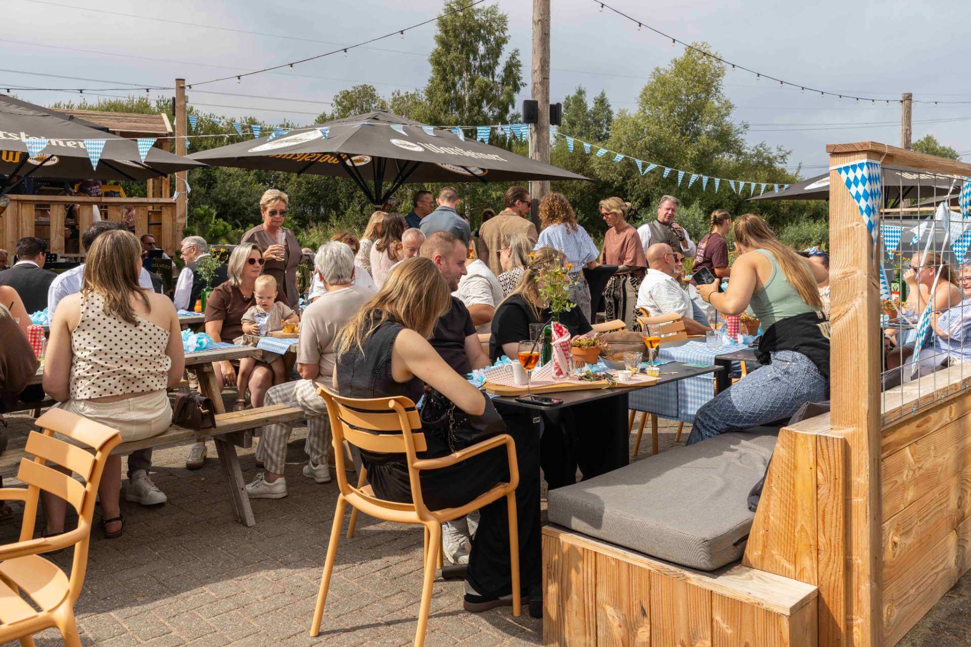 Bedrijfsfeest in de Biergarten van Playdôme Roosendaal met gasten aan lange tafels op het terras.