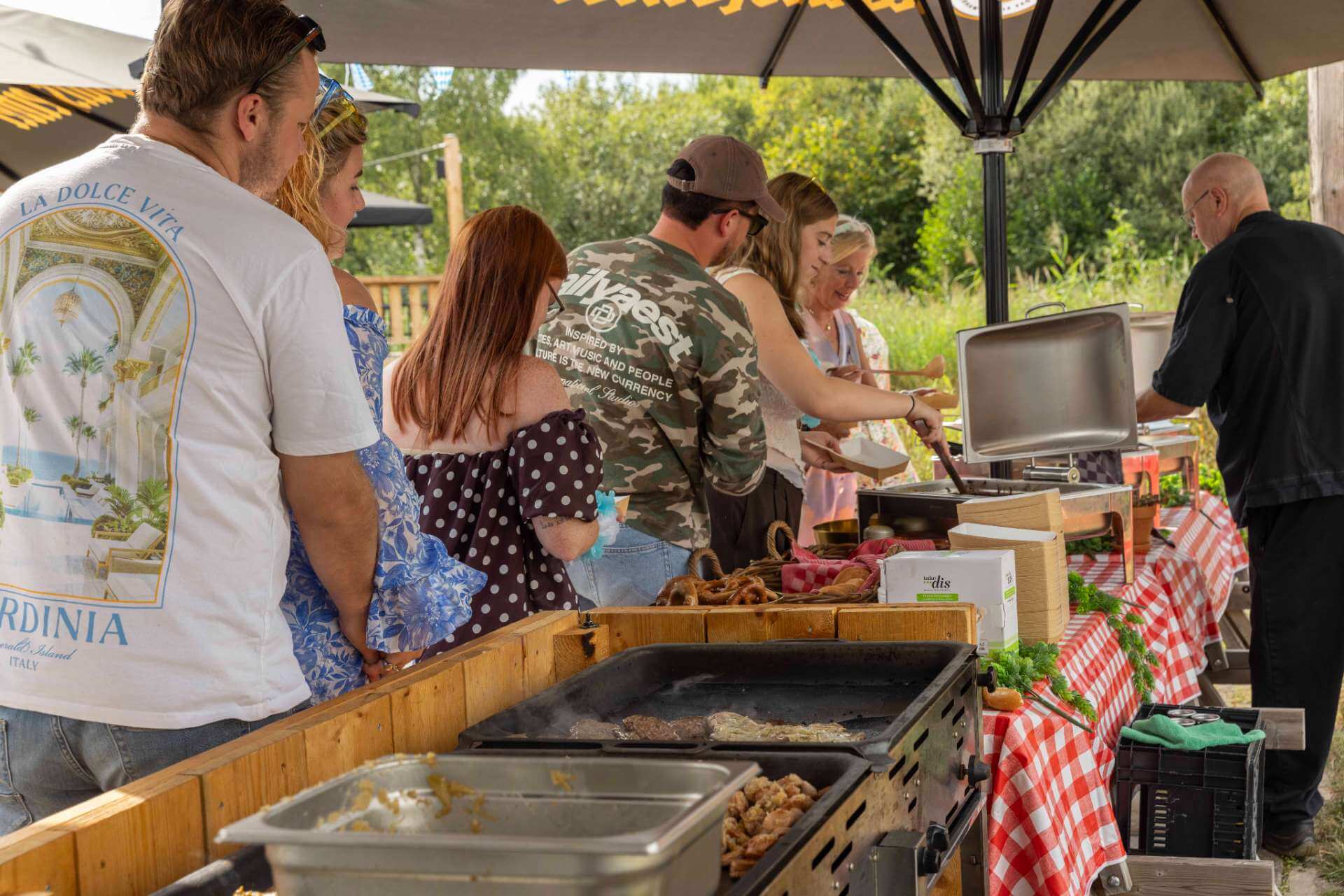 Gasten scheppen eten op bij een buffet tijdens een bedrijfsfeest in de Biergarten van Playdôme Roosendaal.