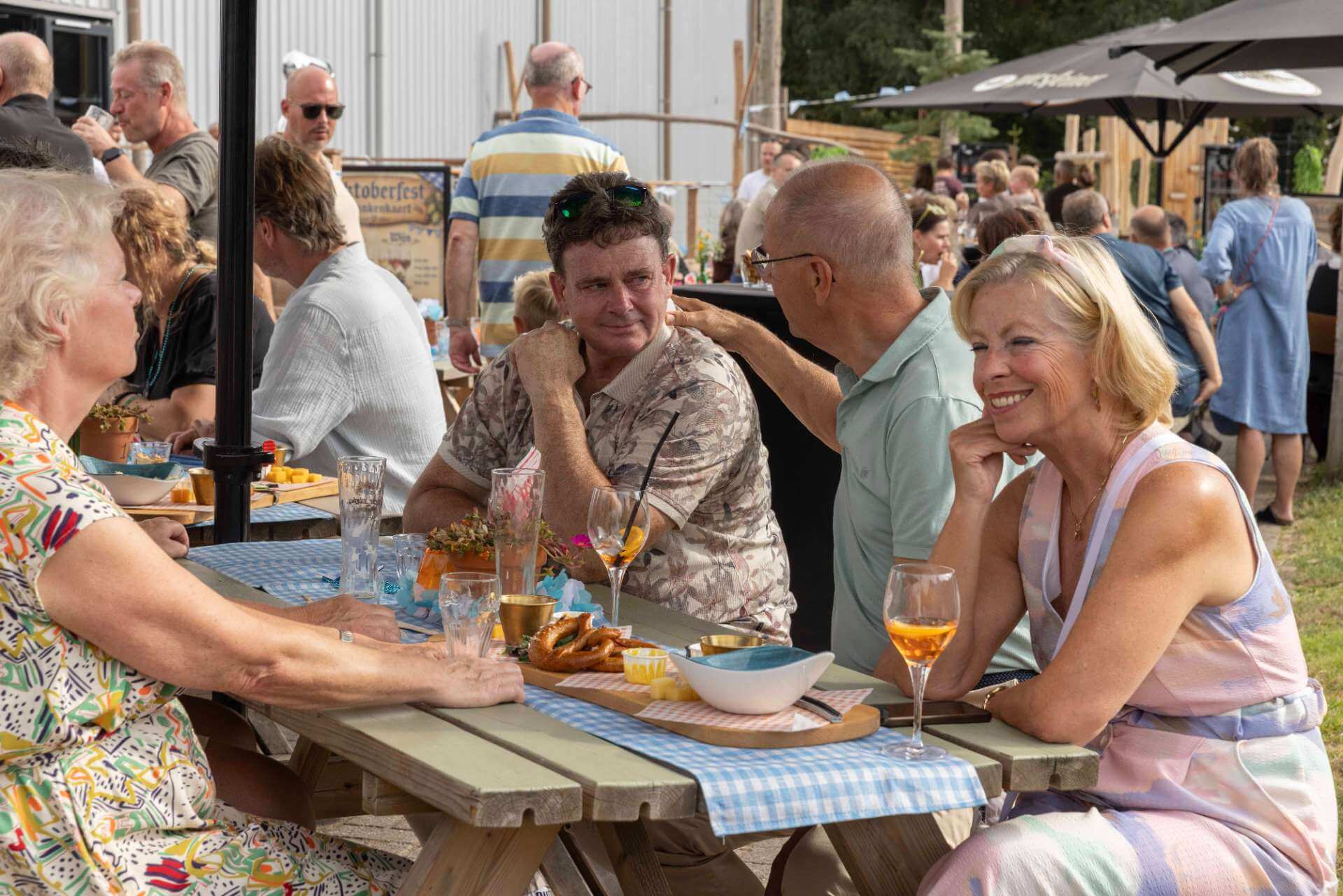 Collega’s zitten samen aan tafel met hapjes en drankjes tijdens een bedrijfsfeest in de Biergarten van Playdôme Roosendaal.
